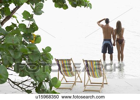 Mid adult couple standing on beach and looking at view, St. John, US Virgin Islands, USA View Large Photo Image Stock Image - Mid adult couple standing on beach and looking at view, St. John, US Virgin Islands, USA. Fotosearch