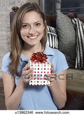 Stock Photograph - Mid-Adult Woman Holding Present. Fotosearch