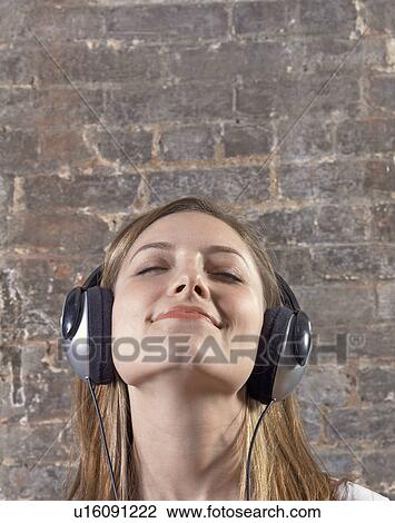 Stock Image - Mid-Adult woman Listening to Headphones. Fotosearch