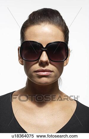 Mid adult woman wearing oversize sunglasses, portrait View Large Photo Image Stock Photography - Mid adult woman wearing oversize sunglasses, portrait. Fotosearch