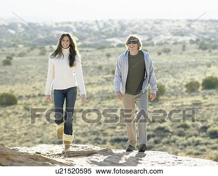 Woman and two men walking on rocky hill View Large Photo Image Stock Photography - Woman and two men walking on rocky hill. Fotosearch