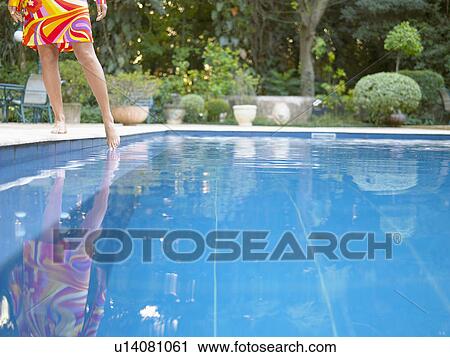 Woman dipping toe in swimming pool (close-up, low angle view) View Large Photo Image Stock Image - Woman dipping toe in swimming pool (close-up, low angle view). Fotosearch
