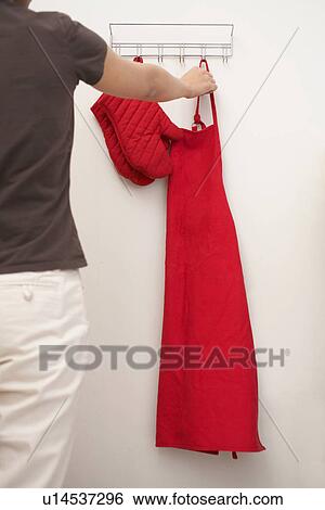 Woman Hanging Apron on Hook View Large Photo Image Stock Photograph - Woman Hanging Apron on Hook. Fotosearch