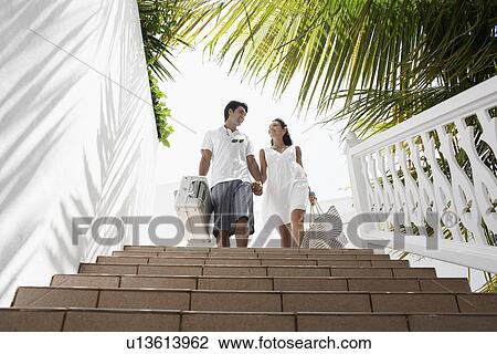 Young couple walking down steps with luggage View Large Photo Image Stock Image - Young couple walking down steps with luggage. Fotosearch