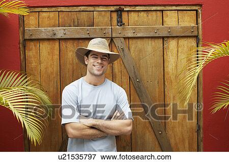 Stock Photo - Young man by wooden window shutters. Fotosearch