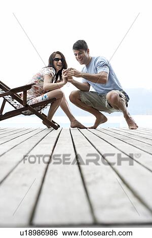 Stock Photograph - Young man showing digital camera to his girlfriend. Fotosearch