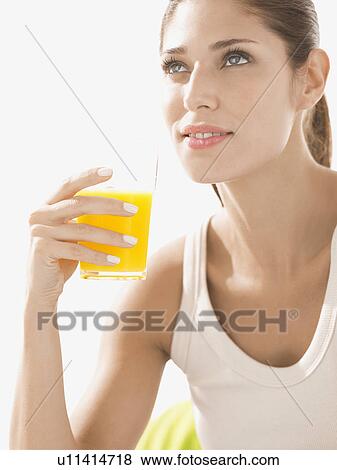 Young woman drinking orange juice View Large Photo Image Stock Photo - Young woman drinking orange juice. Fotosearch