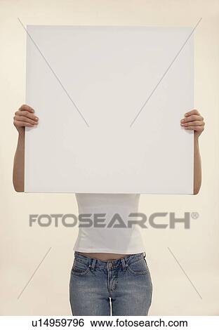 Stock Photograph - Young woman holding blank piece of paper. Fotosearch