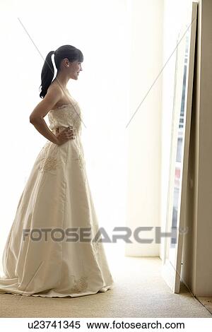 Young woman trying wedding dress on View Large Photo Image Stock Photography - Young woman trying wedding dress on. Fotosearch
