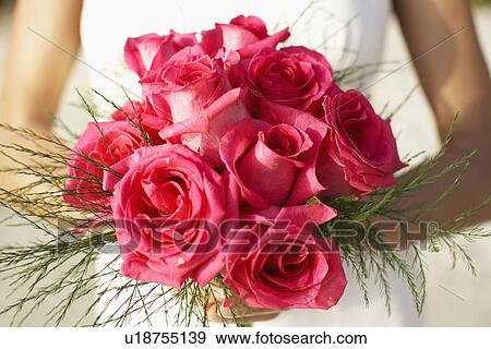 Stock Photo - Bride holding bouquet (mid section). Fotosearch