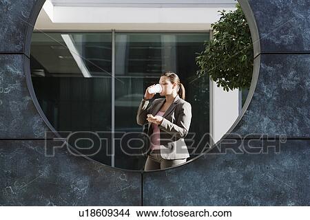 Businesswoman drinking coffee and text messaging View Large Photo Image Picture - Businesswoman drinking coffee and text messaging. Fotosearch