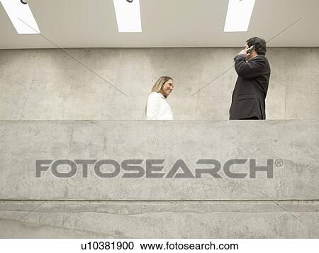 Businesswoman passing man on the phone (low angle view) View Large Photo Image Stock Image - Businesswoman passing man on the phone (low angle view). Fotosearch