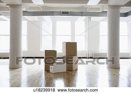 Stock Photo - Cardboard boxes in empty room. Fotosearch