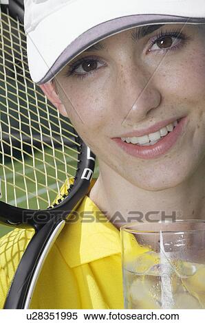 Stock Photography - Female tennis player with glass of water (portrait). Fotosearch