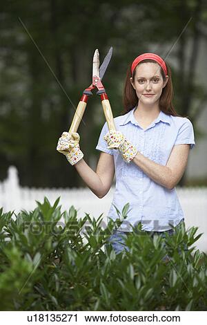 Stock Image - Gardener holding hedge clippers. Fotosearch