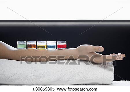 Stock Photography - Jars with liquid on woman's arm (close-up). Fotosearch