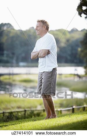 Stock Image - Man standing on lawn and laughing. Fotosearch