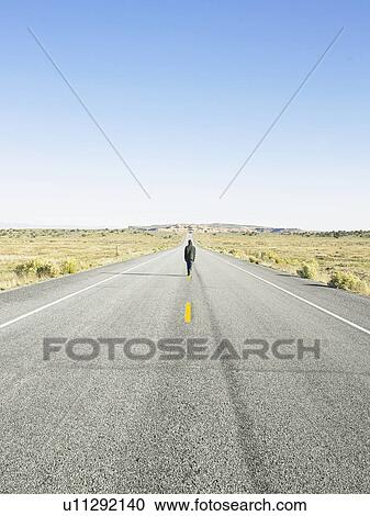 Man walking on centerline of rural road View Large Photo Image Stock Image - Man walking on centerline of rural road. Fotosearch
