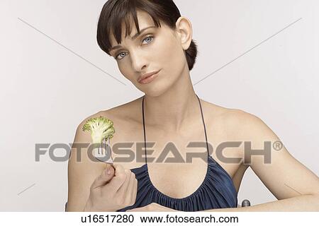 Mid adult woman eating broccoli floret View Large Photo Image Stock Image - Mid adult woman eating broccoli floret. Fotosearch