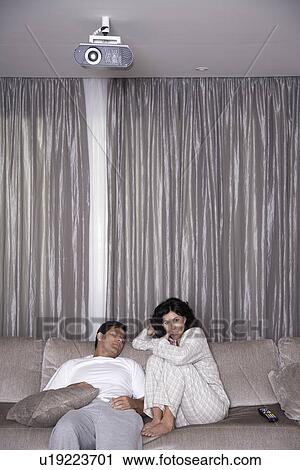 Mid adult woman watching TV next to sleeping man View Large Photo Image Stock Image - Mid adult woman watching TV next to sleeping man. Fotosearch