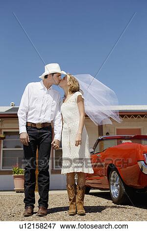 Newlyweds in cowboy attire kissing View Large Photo Image Stock Photo - Newlyweds in cowboy attire kissing. Fotosearch