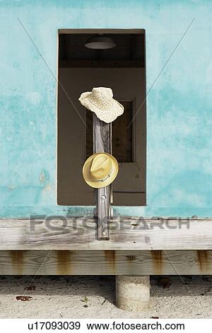 Straw hats on post by doorway View Large Photo Image Stock Photo - Straw hats on post by doorway. Fotosearch