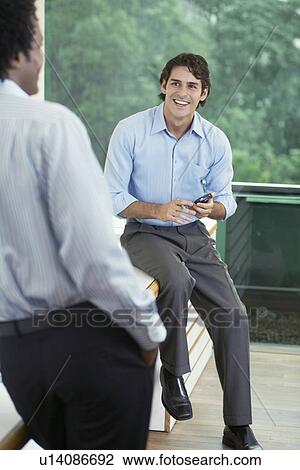 Two businessmen talking View Large Photo Image Stock Image - Two businessmen talking. Fotosearch