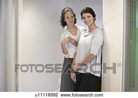 Two Female Office Workers Gossiping in Corridor View Large Photo Image Stock Image - Two Female Office Workers Gossiping in Corridor. Fotosearch