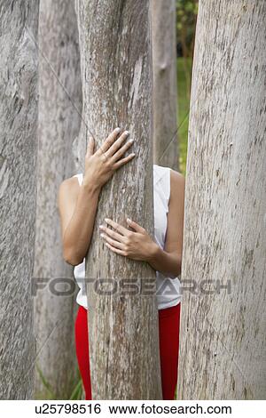 Woman behind tree trunk View Large Photo Image Stock Photograph - Woman behind tree trunk. Fotosearch