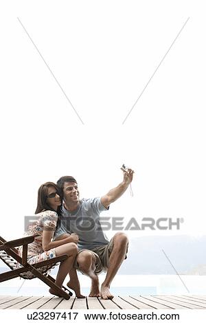 Stock Photo - Young couple photographing themselves. Fotosearch