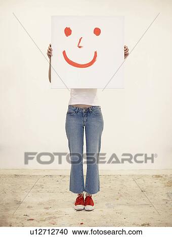 Young woman holding drawing of smiley face View Large Photo Image Stock Image - Young woman holding drawing of smiley face. Fotosearch