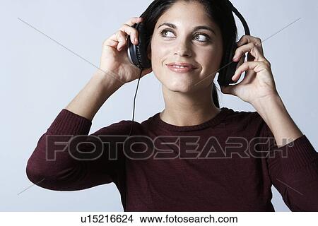 Young woman listening to headphones View Large Photo Image Picture - Young woman listening to headphones. Fotosearch