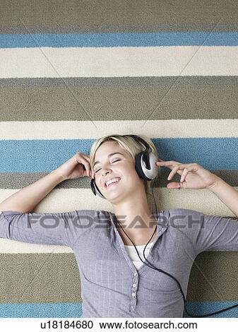 Stock Image - Young Woman Listening to Headphones. Fotosearch