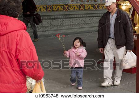 Stock Photo - Little girl holding flowers. Fotosearch