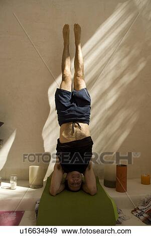 Stock Photo - Man in headstand yoga position. Fotosearch