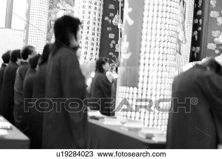 Stock Image - People standing infront oriental display. Fotosearch