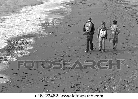 Stock Image - People walking along beach. Fotosearch