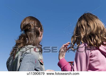 Stock Photo - Two girls facing backwards. Fotosearch