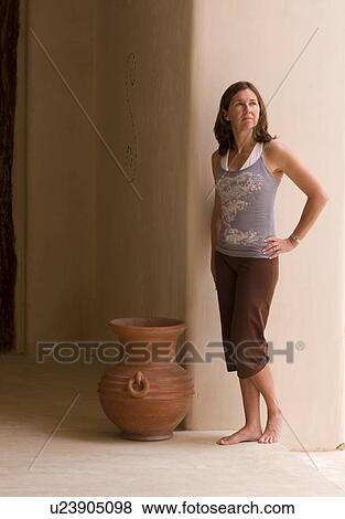 Stock Photo - Woman standing beside Mexican pottery. Fotosearch