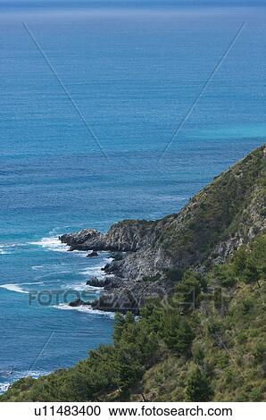Aerial view of coastline with blue sea and surf against rocks View Large Photo Image Stock Image - Aerial view of coastline with blue sea and surf against rocks. Fotosearch