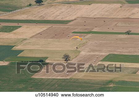 Aerial view of plain outside Norcia, with pattern created by cultivated green and brown fields, and paragliders landing View Large Photo Image Stock Image - Aerial view of plain outside Norcia, with pattern created by cultivated green and brown fields, and paragliders landing. Fotosearch