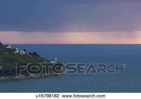 Stock Image - Agropoli lighthouse and harbour in approaching storm at dusk. Fotosearch