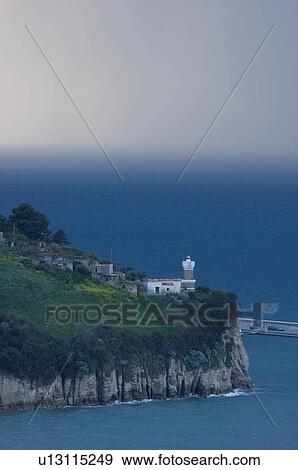 Stock Photo - Agropoli lighthouse and harbour in approaching storm at dusk. Fotosearch