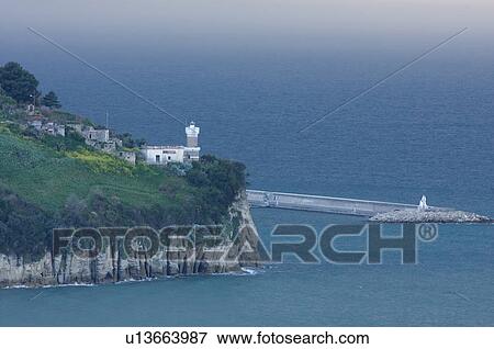Stock Photo - Agropoli lighthouse and harbour in approaching storm at dusk. Fotosearch