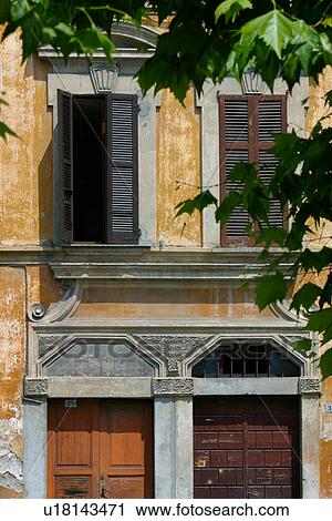 Stock Image - Architectural detail of doors and windows, ochre painted walls and stone pediments. Fotosearch