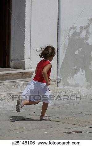 Stock Photograph - back view of child running on empty street. Fotosearch