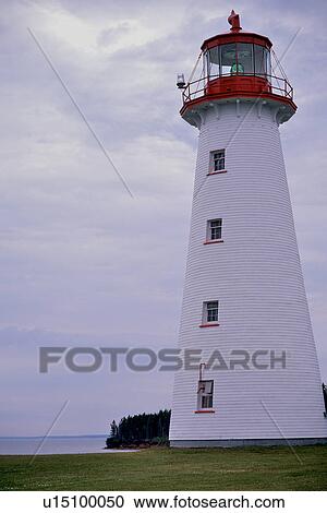 Stock Image - Beach lighthouse against sky, with sea beyond. Fotosearch