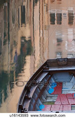 Stock Image - Brightly coloured boat moored, with building reflections in canal. Fotosearch