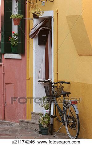 Stock Photograph - Burano bicycle parked outside bright colour house. Fotosearch
