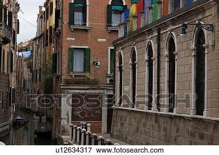 Stock Photo - canal with bright coloured fence, laundry and boats. Fotosearch